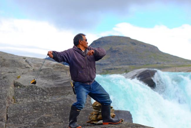 Lukassi Etoq and his slingshot at the edge of the Qurlutuarjuq Falls on the Koroc River, in Kuururjuaq National Park