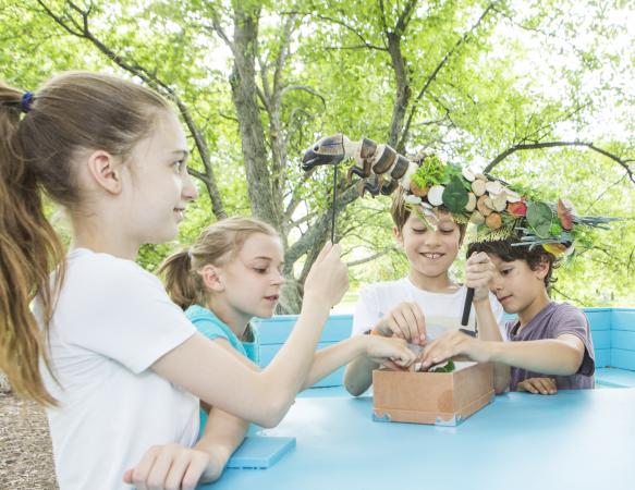 Children having fun with a caddisfly puppet on the “Nature is your Shelter” immersive pathway