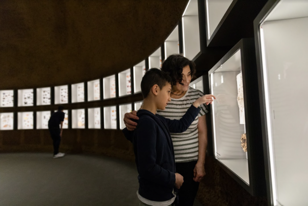 A mother and her son are looking at some insects in the showcases of the Insectarium Dome.