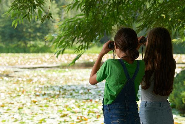 Deux jeunes filles regardent la nature avec des jumelles au Jardin botanique de Montréal