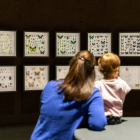 A mother and her young daughter are looking at the showcases of the Insectarium Dome.